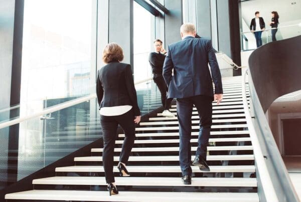 Office Building Insurance - Business Colleagues Walking up the Stairs of a Modern Corporate Office Building in a Large City