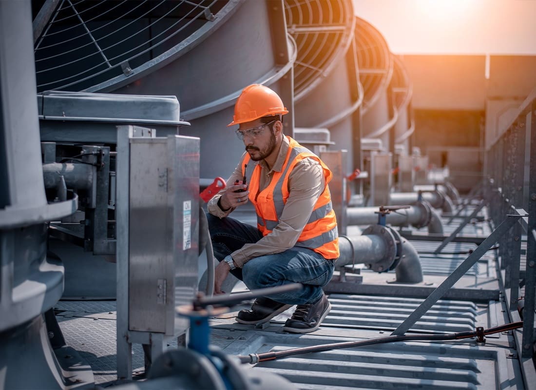 Business Insurance - Engineer Checking a Cooling Tower on Top of a Large Industrial Building