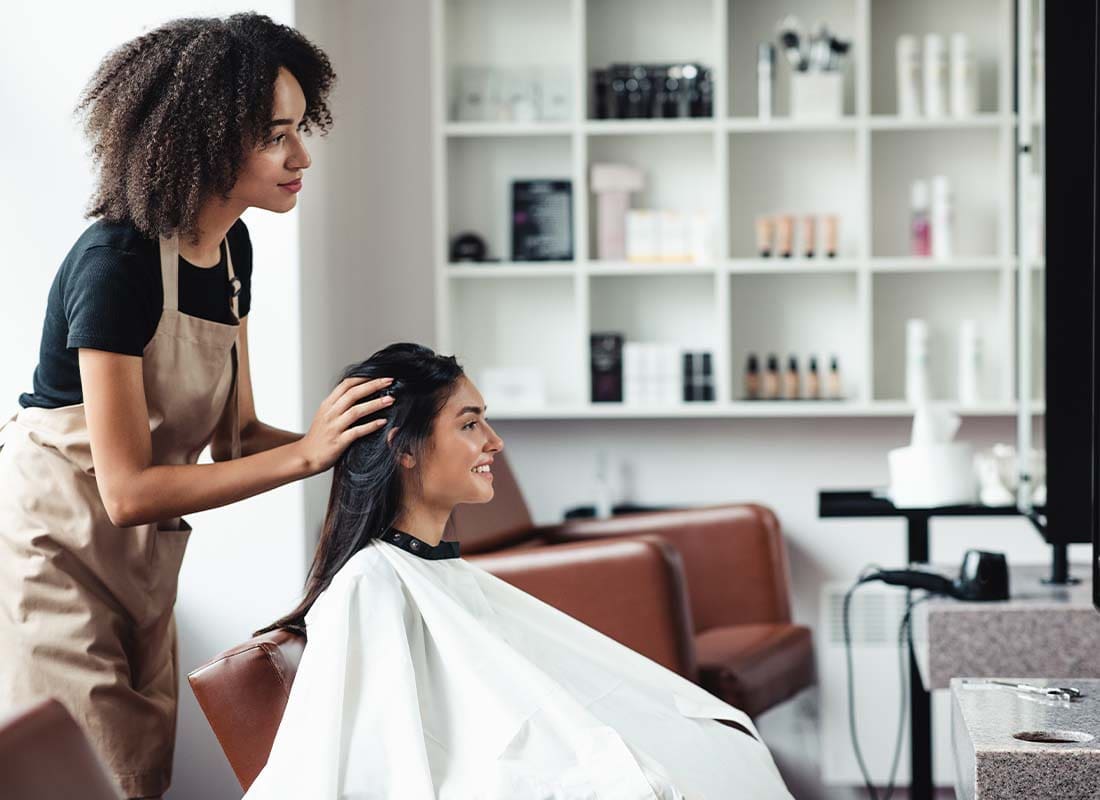 Beauty-Salon-Insurance-Young-Woman-Looking-for-Changes-and-Getting-Hairstyle-Advice-from-Stylist-at-a-Beauty-Salon